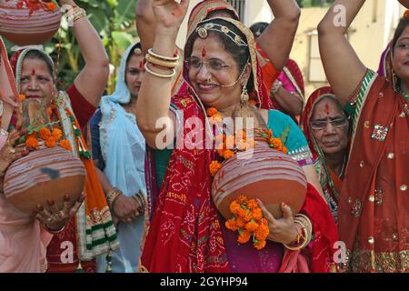 Beawar, India. 07th Oct, 2021. Beawar, Rajasthan, India, Oct.7, 2021: Rajasthani women dance during kalash yatra on the first day of the 9-day long Navratri festival in Beawar. Navratri festival marks the victory of Goddess Durga over the evil buffalo demon Mahishasura. Thus, Durga Puja festival epitomises the victory of Good over Evil in Hindu mythology, culminates in the immersion of idols in bodies of water. The festival will continue till October 15. Credit: Sumit Saraswat/Alamy Live News Stock Photo