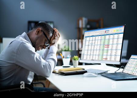 Stressed Depressed African Man At Desk. Tired Bored Businessman Stock Photo