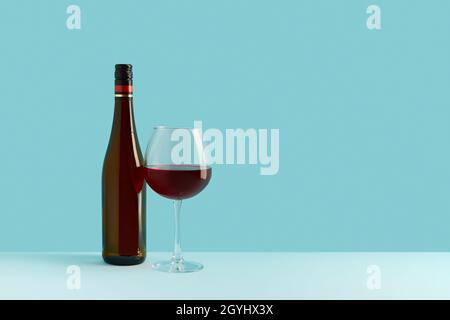 Bottle and glass of red wine on blue background. Mock up drink with place for you lable and text Stock Photo