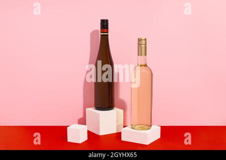 Bottles of wine on red and pink background with deep shadows. Mock up drink with place for you lable and text Stock Photo