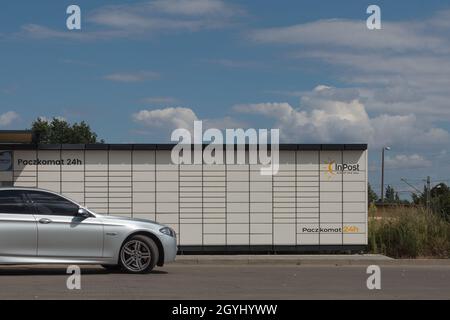 POZNAN, POLAND - Sep 16, 2021: InPost parcel lockers in Poznan, a car parked in front of a parcel locker. Stock Photo