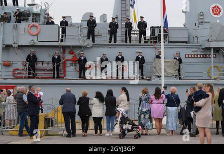 Portsmouth, UK. 8th Oct, 2021. Family members greet returning navy personnel from HMS Brocklesby at the ship arrives at HMNB Portsmouth. Due to Covid-19 it's the first homecoming since December 2019 at which families have been allowed on the jetties to greet a returning ship. Brocklesby has been in the Gulf for three years. Picture by Finnbarr Webster/Alamy Live News Stock Photo