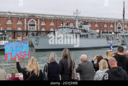 Portsmouth, UK. 8th Oct, 2021. Family members greet returning navy personnel from HMS Brocklesby at the ship arrives at HMNB Portsmouth. Due to Covid-19 it's the first homecoming since December 2019 at which families have been allowed on the jetties to greet a returning ship. Brocklesby has been in the Gulf for three years. Picture by Finnbarr Webster/Alamy Live News Stock Photo