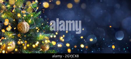 Christmas Tree In Blue Night - Golden Balls On Fir Branches With Defocused Lights In Abstract Background Stock Photo