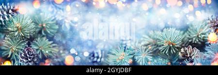 Snowy Fir branch With Christmas Light - Winter Card With Abstract Defocused Background Stock Photo