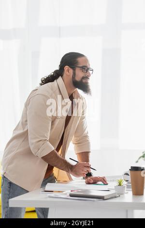 thoughtful hispanic architect looking away while working at home Stock Photo