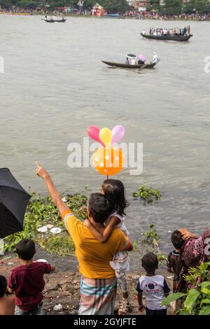 Spectator of boat race enjoying on the riverbank . This image has been captured on September-28- 2021 from Dhaka, Burigongga river, Bangladesh, South Stock Photo