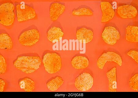 Collection of fried potato chips snack on orange background. Chilli and potato taste. Junk food Stock Photo