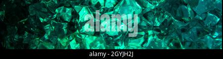 Banner Bright green crystals from glass close-up look like gems in blurry light. Background from crystals of blue stones. Close-up. Stock Photo