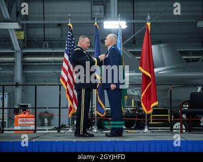 Army Brig. Gen. Greg Knight, the adjutant general of the Vermont National Guard, presents Col. David Smith, outgoing commander of the 158th Fighter Wing, Vermont Air National Guard, the Legion of Merit for his leadership of the wing during a change of command ceremony for the 158th Fighter Wing, Vermont Air National Guard Base, South Burlington, Vt., Jan. 5, 2020. Col. David Shevchik Jr. takes command of the wing from Smith who is retiring after more than 30 years in the Vermont Air National Guard. (U.S. Air National Guard photo by Tech. Sgt. Ryan Campbell) Stock Photo