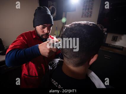 U.S. Coast Guard Petty Officer 2nd Class Jose Tamayo, 32, of Miami, cuts the hair of a crew member of the Coast Guard Cutter Polar Star (WAGB-10) Jan. 6, 2020, about 10 miles north of McMurdo Station, Antarctica.  The crew of the Polar Star, a 399-foot heavy icebreaker, is working to break a channel in the ice surrounding McMurdo Station in order to bring in refuel and resupply vessels as part of Operation Deep Freeze — the U.S. military’s contribution to the National Science Foundation-managed, civilian U.S. Antarctic Program.  U.S. Coast Guard photograph by Senior Chief Petty Officer NyxoLyn Stock Photo
