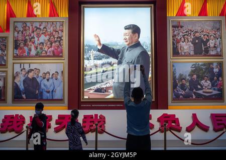 People look at images showing Chinese President Xi Jinping at the Museum of the Communist Party of China in Beijing. 08-Oct-2021 Stock Photo