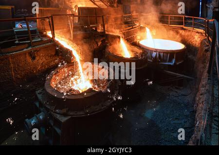 Blast furnace slag and pig iron tapping. Molten metal and slag are poured into a ladle. Stock Photo