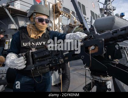 200111-N-TI693-1106    MEDITERRANEAN SEA (Jan. 11, 2020) - Yeoman Seaman Apprentice Ivan Flores, from Dallas, loads a .50-caliber machine gun during a crew serve weapons qualification aboard the Arleigh Burke-class guided-missile destroyer USS Carney (DDG 64), Jan. 11, 2020. Carney, forward-deployed to Rota, Spain, is on its seventh forward deployed naval force patrol in the U.S. 6th Fleet area of operations in support of regional allies and partners as well as U.S. national security interests in Europe and Africa. (U.S. Navy photo by Mass Communication Specialist 1st Class Fred Gray IV/Releas Stock Photo