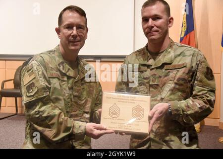 U.S. Air Force North Carolina Assistant Adjutant General for Air, Brig. Gen. Stephen Mallette (left), presents Master Sgt. Daniel Judd, 263rd Combat Communications Squadron (right), with an award during an all-call held at the New London, N.C. Air National Guard Base (NCANG) headquarters, Jan. 12, 2020. Members of the NCANG celebrated the accomplishments of Master Sgt. Judd who attended the United States Marine Corps Staff Non-Commissioned Officer Academy last year in an effort to better understand the traditions and customs of a sister service. Since attending the academies, Judd has implemen Stock Photo