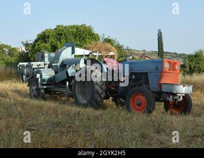 Tractor working in a wheat field Stock Photo