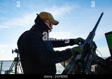 200117-N-OX360-1026  ATLANTIC OCEAN. (Jan. 17, 2020) Retail Services Specialist Seaman Daniel Kim, from Chino, California, loads a .50-caliber machine gun aboard the aircraft carrier USS Dwight D. Eisenhower (CVN 69). Ike is conducting operations in the Atlantic Ocean as part of the USS Dwight D. Eisenhower Strike Group.(U.S. Navy photo by Mass Communication Specialist 3rd Class James Norket) Stock Photo