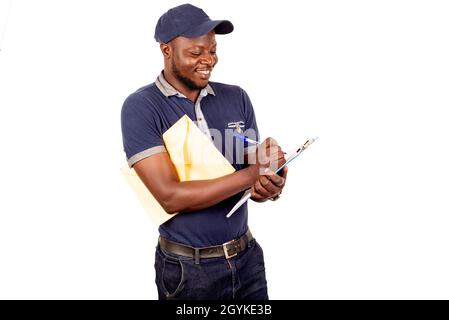 young delivery man in cap isolated on white background noting his order smiling. Stock Photo