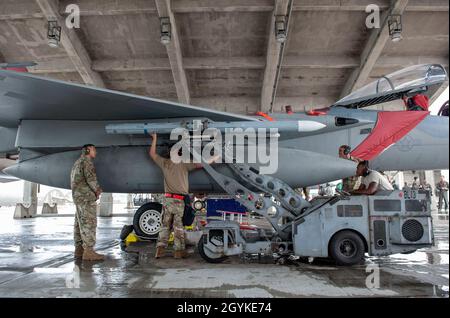 A weapons load team from the 44th Aircraft Maintenance Unit loads an ...