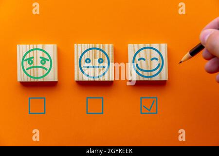 Orange background with emotion tiles and checkboxes for customer satisfaction surveys Stock Photo