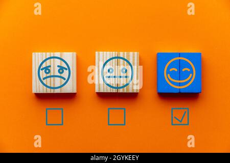 Orange background with emotion tiles and checkboxes for customer satisfaction surveys Stock Photo