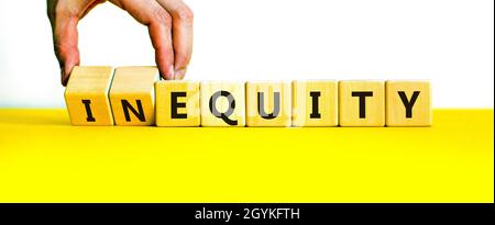 Inequity or equity symbol. Businessman turns wooden cubes and changes the word inequity to equity. Business and inequity or equity concept. Beautiful Stock Photo