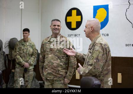 Staff Sgt. Andrew Stoltz with the 108th Sustainment Brigade, Task Force Lincoln, Team Blackhawks, Illinois Army National Guard, receives a commander’s coin of excellence and certificate from Maj. Gen. John P. Sullivan, commander of the 1st Theater Sustainment Command in the US Central Command area of operations, Jan. 21. 2020. Stoltz was selected as the 1st TSC Sustainer of the Week.  Soldiers from Team Blackhawks of the Illinois Army National Guard are executing the logistics advise, assist, and enable mission under the 1st Theater Sustainment Command supporting Combined Joint Task Force — Op Stock Photo