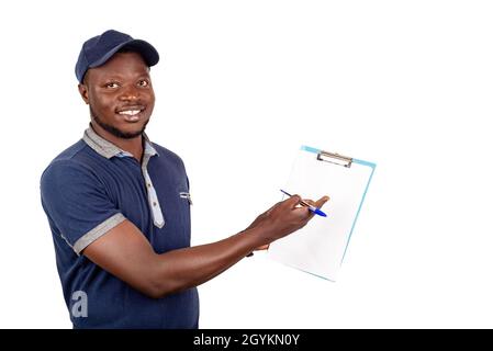 young delivery man standing in blue uniform standing holding and showing a clipboard with empty document with pen in smiling Stock Photo