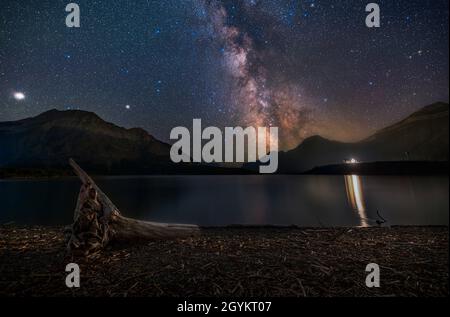 The northern summer Milky Way over Middle Waterton Lake at Driftwood Beach in Waterton Lakes National Park, Alberta on a July night. Sagittarius is at Stock Photo