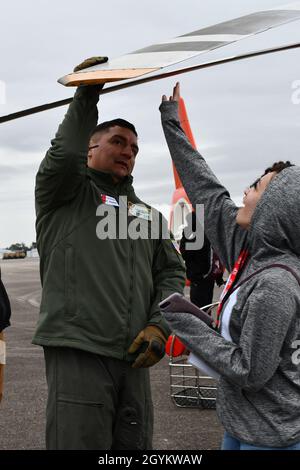 United States Coast Guard rescue swimmer, Petty Officer 2nd Class Omar Alba who hails from El Paso, Texas and is assigned to U.S. Coast Guard Air Station-Savannah, demonstrates how a rotary wing blade on a MH65D helicopter flexes up and down to a group of high school students and faculty members from Savannah-Chatham County Public Schools during a leadership and connections symposium sponsored by local industry leaders in Savannah, Ga., Jan. 23, 2020. Alba and a team from USCG Air Station Savannah spoke of their experiences and the MH65D helicopter as part of the overall event designed to enha Stock Photo