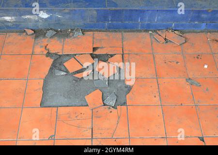 Old and broken floor tiles, Close up of a cracked ceramic tiles, floor surface due to improper residential construction material. Stock Photo