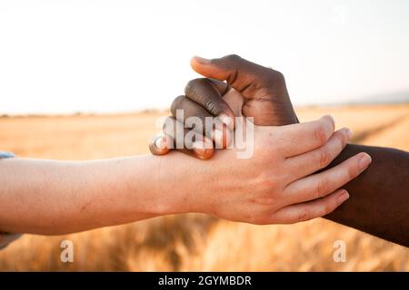 Multiracial relationship and friendsip concept. Two hands holding together. Stock Photo