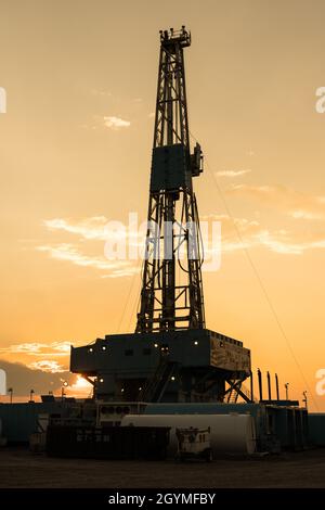 Sunset behind a 3000 hp top drive drilling rig drilling for oil in the Green River Desert in central Utah. Stock Photo