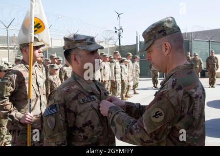 Newly promoted Maj. Dino De La Hoya gets pinned with his new rank by Brig. Gen. Howard Geck, commanding general, 103rd Expeditionary Sustainment Command, during an award, patching, and promotion ceremony at Camp Arifjan, Kuwait, Feb. 2, 2020. (U.S. Army Reserve photo by Spc. Dakota Vanidestine) Stock Photo