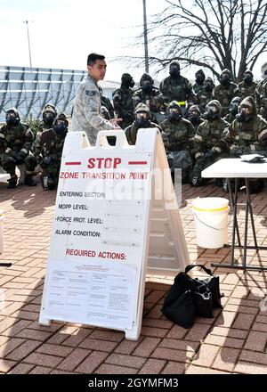 Staff Sgt. Thinh Tran, 104th Emergency Management journeyman, explains Mission Oriented Protective Posture Gear zone transitions during a Chemical, Biological, Radiological, and Nuclear exercise Feb. 2, 2020, at Barnes Air National Guard Base, Massachusetts. The CBRN training gets Airmen comfortable with putting on their MOPP gear and effectively performing their jobs with reduced dexterity.  (U.S. Air National Guard photo by Airman 1st Class Sara Kolinski) Stock Photo