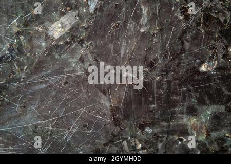 Texture of natural polished scratched  black labradorite stone. Abstract background. Stock Photo