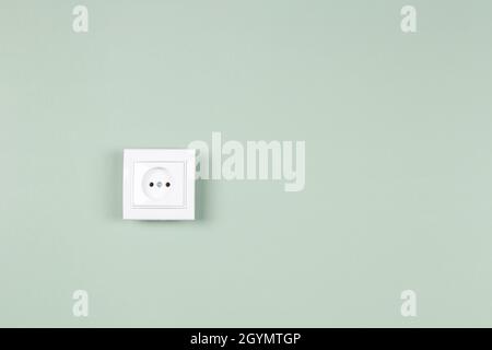 White electric socket on yellow background. One electrical outlet on the wall Stock Photo