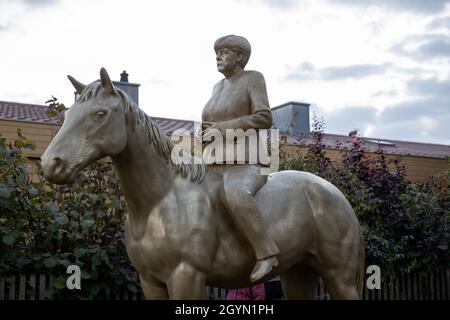 Etsdorf, Germany. 08th Oct, 2021. An equestrian statue of still-Federal Chancellor Angela Merkel after the unveiling. The 2.70-meter-high life-size sculpture was made of lightweight concrete and by means of a corresponding 3D printer. The idea came from the artist Wilhelm Koch, who for decades has been realizing unusual projects such as an air museum with sculptures made from inflated rubber hoses. Credit: Daniel Karmann/dpa/Alamy Live News Stock Photo