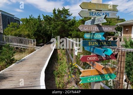 Colorful signpost along the boardwalk in Cherry Grove, Fire Island, Suffolk County, New York, USA. Stock Photo