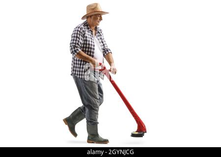 Full length shot of a mature man walking and using a grass trimmer isolated on white background Stock Photo