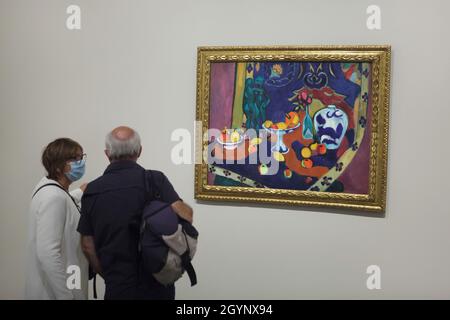 Visitors wearing face masks in front of the painting 'Fruits and Bronze' by French painter Henri Matisse (1910) displayed at the exhibition 'Icons of Modern Art from the Morozov Collection' in the Fondation Louis Vuitton in Paris, France. The exhibition runs till 22 February 2022. Stock Photo