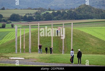 Hessen, Germany. 08th Oct, 2021. 08 October 2021, Hessen, Glauburg: Visitors to the Celtic World at Glauberg view the reconstructed burial mound and a group of wooden posts. In 1994, a research team had begun excavations and discovered, among other things, the now world-famous statue of the 'Celtic Prince of the Glauberg'. The Celtic settlement in the Wetterau region is to become a Unesco World Heritage Site. The federal states have to submit their proposals for the national preselection procedure to the Conference of Ministers of Culture by October 31. (to dpa 'May settlements and Celts to be Stock Photo