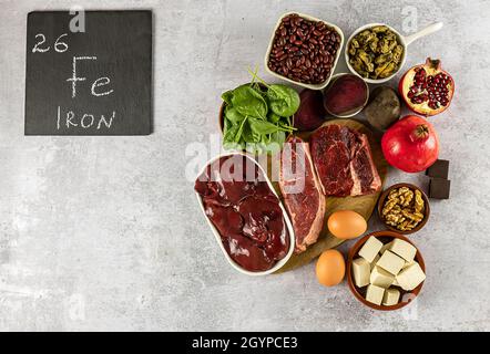 Foods high in Iron, including eggs, nuts, spinach, beans, tofu, liver, beef, beetroot, mussels, and dark chocolate.  Stock Photo