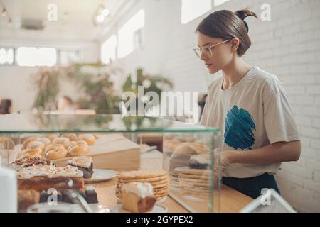 Charming young woman working in bakery shop Stock Photo