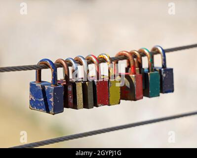 rusty old colourful padlocks on steel wire Stock Photo