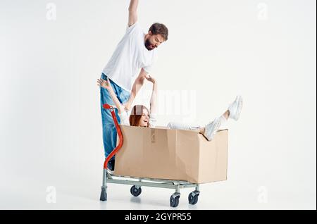 a young couple ride a cart entertainment light background Stock Photo