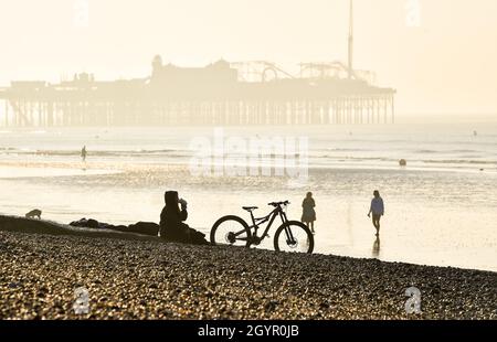 Brighton UK 9th October 2021 - Time to relax on Brighton beach on a beautiful sunny morning as warm sunny weather is forecast for parts of the UK today : Credit Simon Dack / Alamy Live News