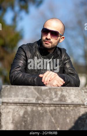 Portrait of a handsome bearded man from Poland wearing sunglasses and a leather jacket Stock Photo