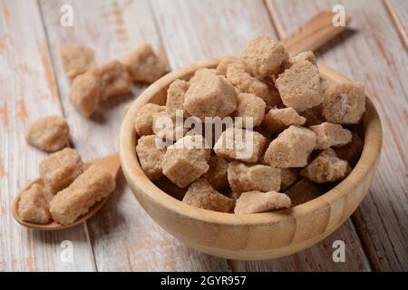 Demerara brown sugar cubes in wooden bowl. Also called sugar lumbs. Sucrose sugar product with distinctive brown color due to the presence of molasses Stock Photo