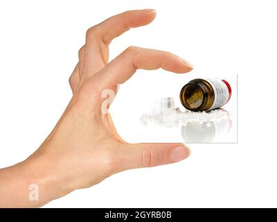 Women Hand holding Card with Homeopathy Pills isolated on white Background Stock Photo